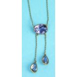 An Edwardian amethyst necklace collet-set an oval amethyst with two asymmetric amethyst drops below,