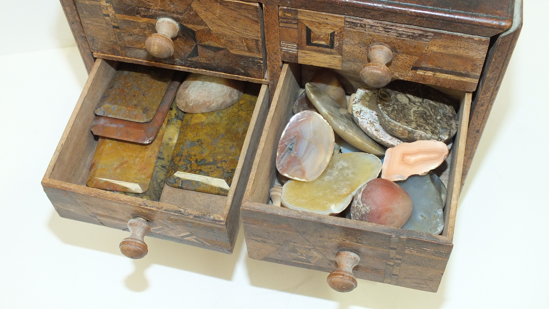 A small wooden chest with an arrangement of five marquetry-decorated drawers, 18cm wide, 15.5cm