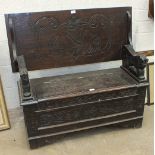 An early-20th century carved oak monk's bench with folding back and lift seat, 106cm wide.