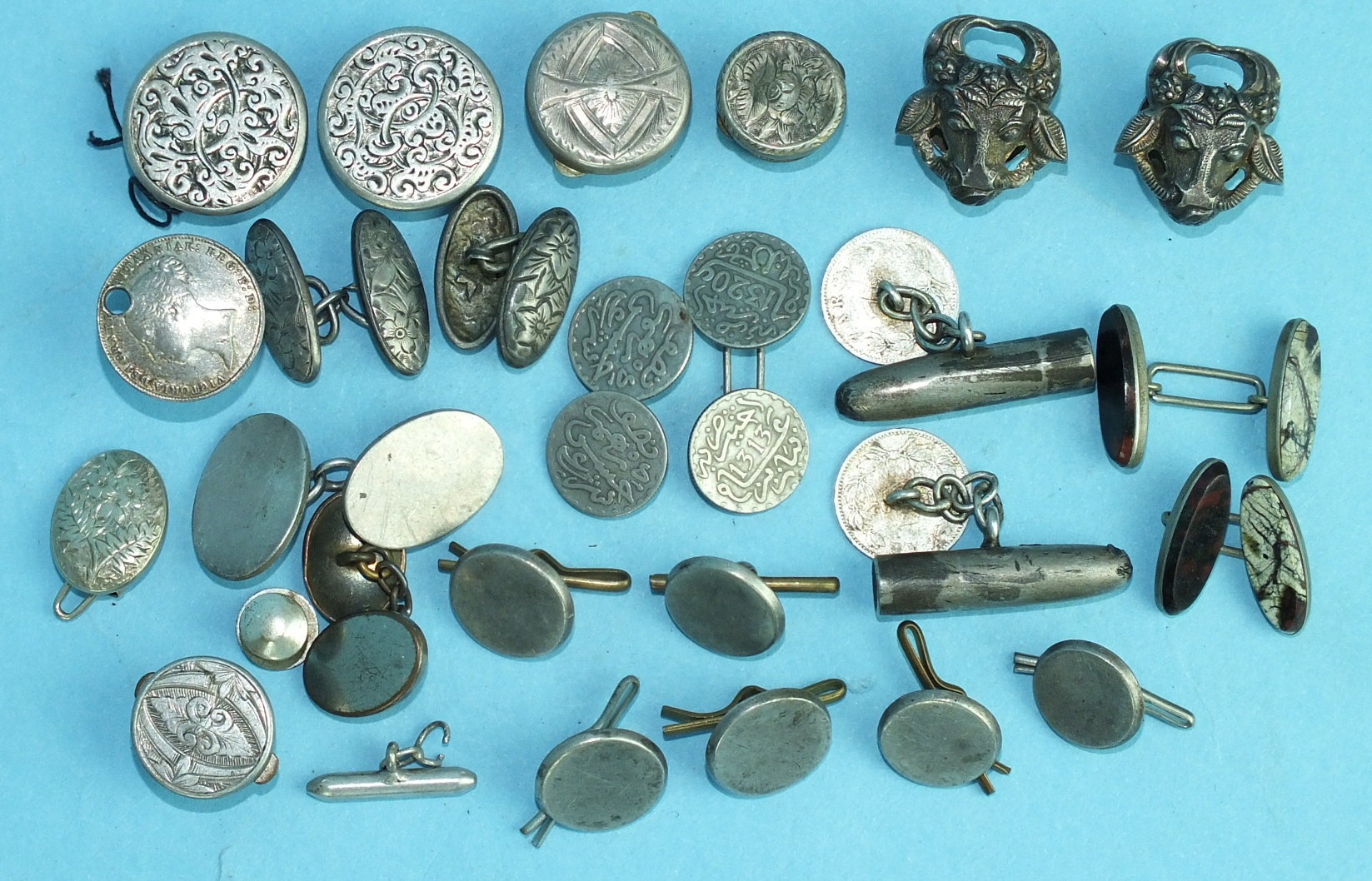 A pair of lapel badges in the form of bull's heads, a pair of bullet cufflinks, six silver buttons