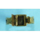 A Victorian yellow metal mourning ring, the hinged front opening to reveal a locket within, (vacant,