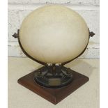 An Ostrich egg on gilt metal and ebony stand, with plaque engraved 'South Africa 1908', 21cm high