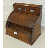 An Edwardian oak stationery box, the perpetual calendar above a tambour front, with fitted