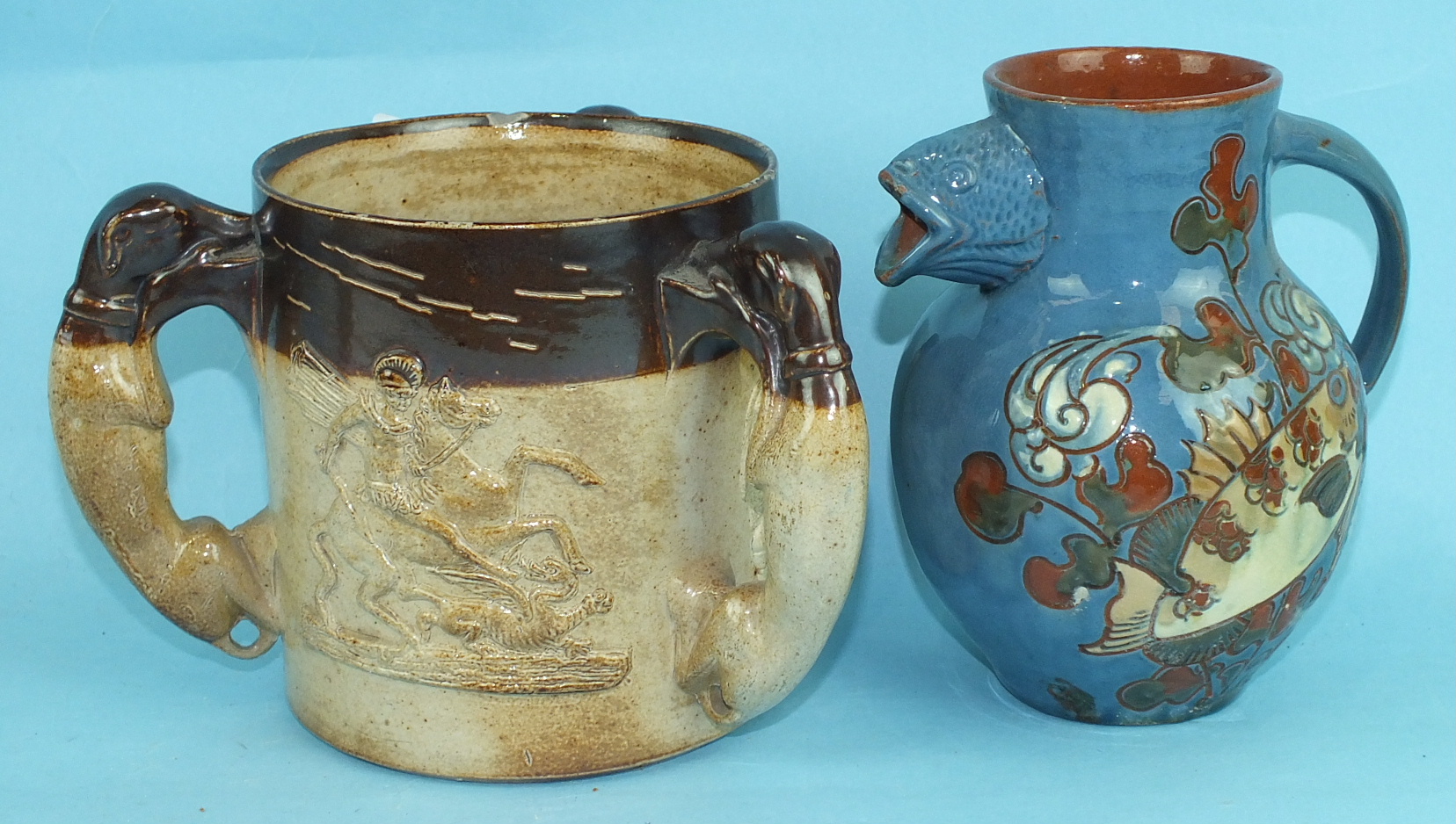 A Brannam Pottery slip-decorated fish jug and a 19th century stoneware tyg with St George & Dragon