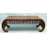 A Chinese hardwood low occasional table with pierced prunus frieze, on scroll supports, 101cm wide.