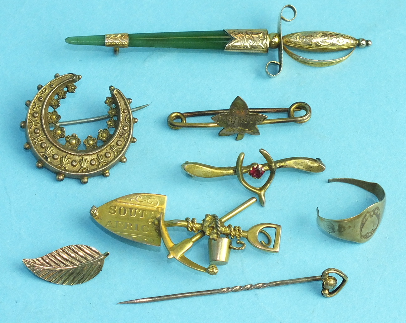 A yellow-metal-mounted jade brooch in the form of a sword, various other brooches, etc, weighable