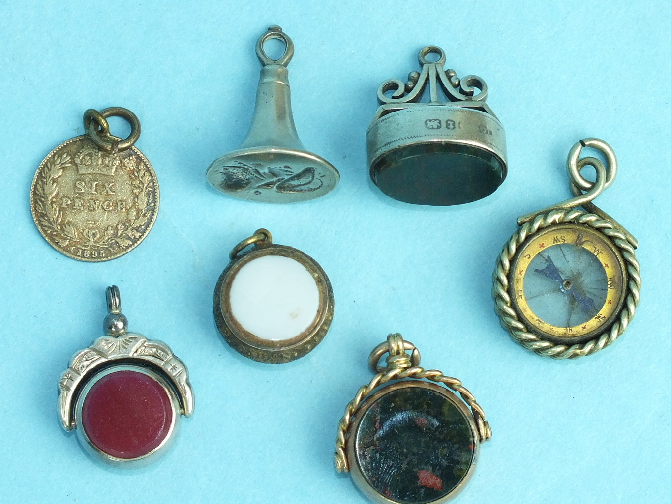 A 9ct gold-mounted swivel fob, (a/f), a white metal seal, two silver-mounted agate seals, two fob