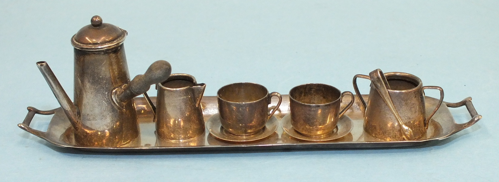 A miniature silver coffee service, comprising: wooden-handled coffee pot, sugar basin with tongs,