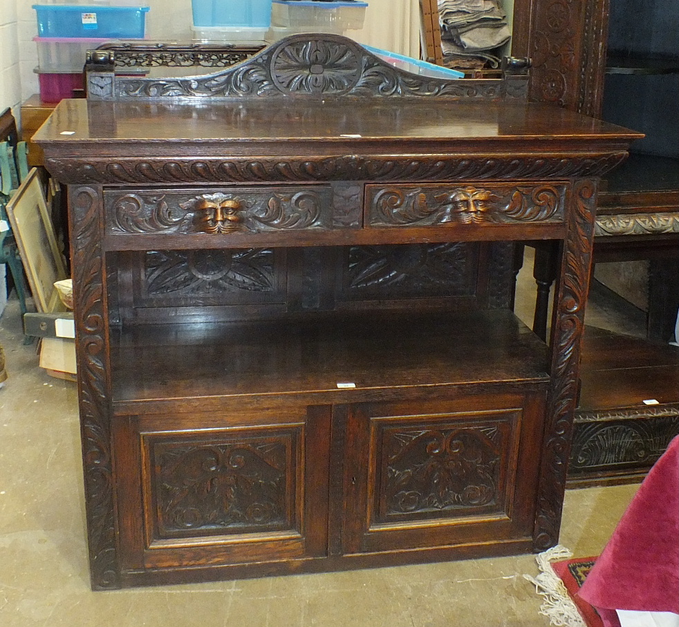 A Victorian carved oak two-tier buffet having a pair of frieze drawers above a shelf and two