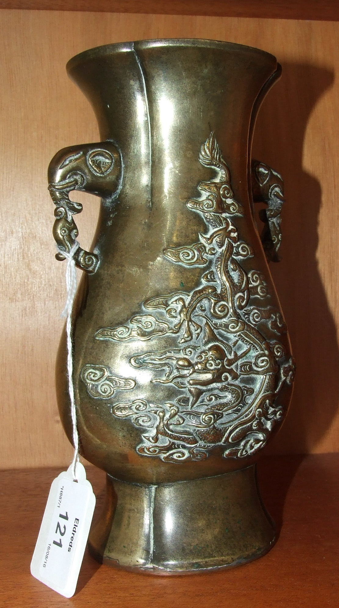 An antique Chinese bronze vase with elephant's head handles and flattened baluster form, 20cm high.