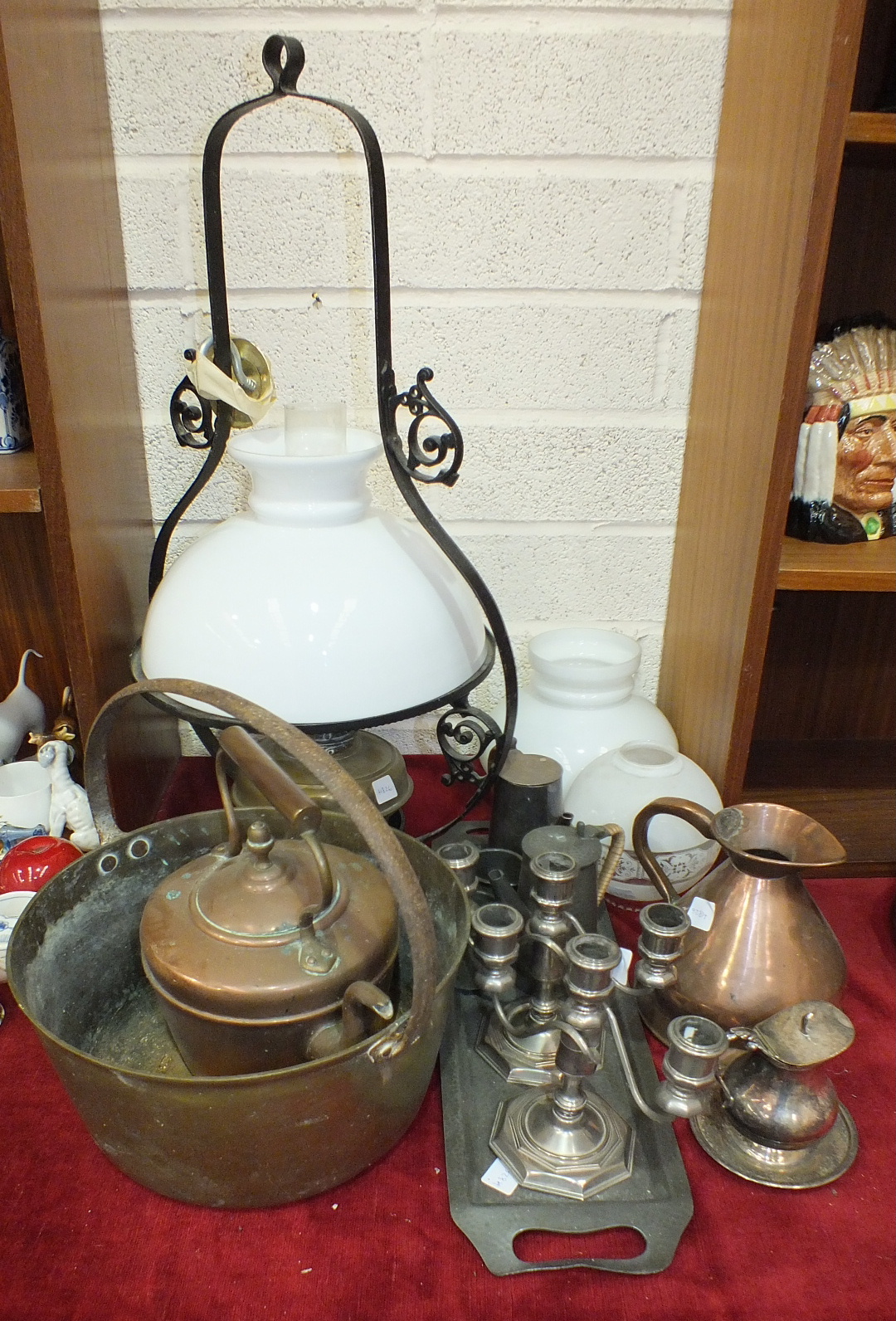 A brass oil lamp on hanging metal fitting, a brass jam pan with metal handle, a copper quart