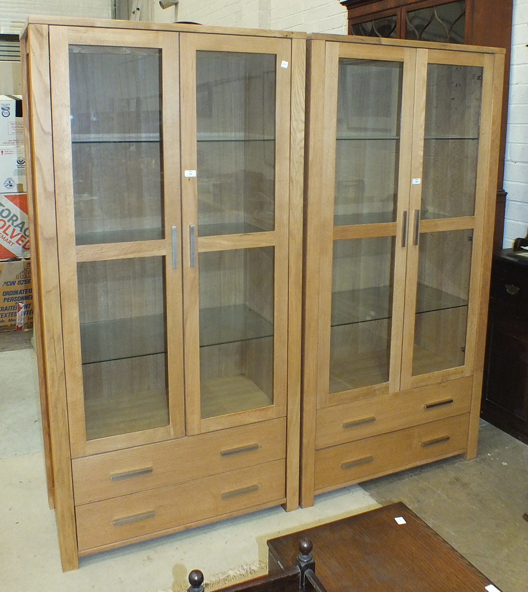 A pair of modern Oaklands Furniture oak display cabinets, each fitted with a pair of glazed doors