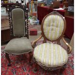 A Victorian low nursing chair with upholstered spoon back and seat, carved frame and cabriole