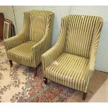 A pair of Edwardian wing armchairs with square tapered legs, (one leg a/f).