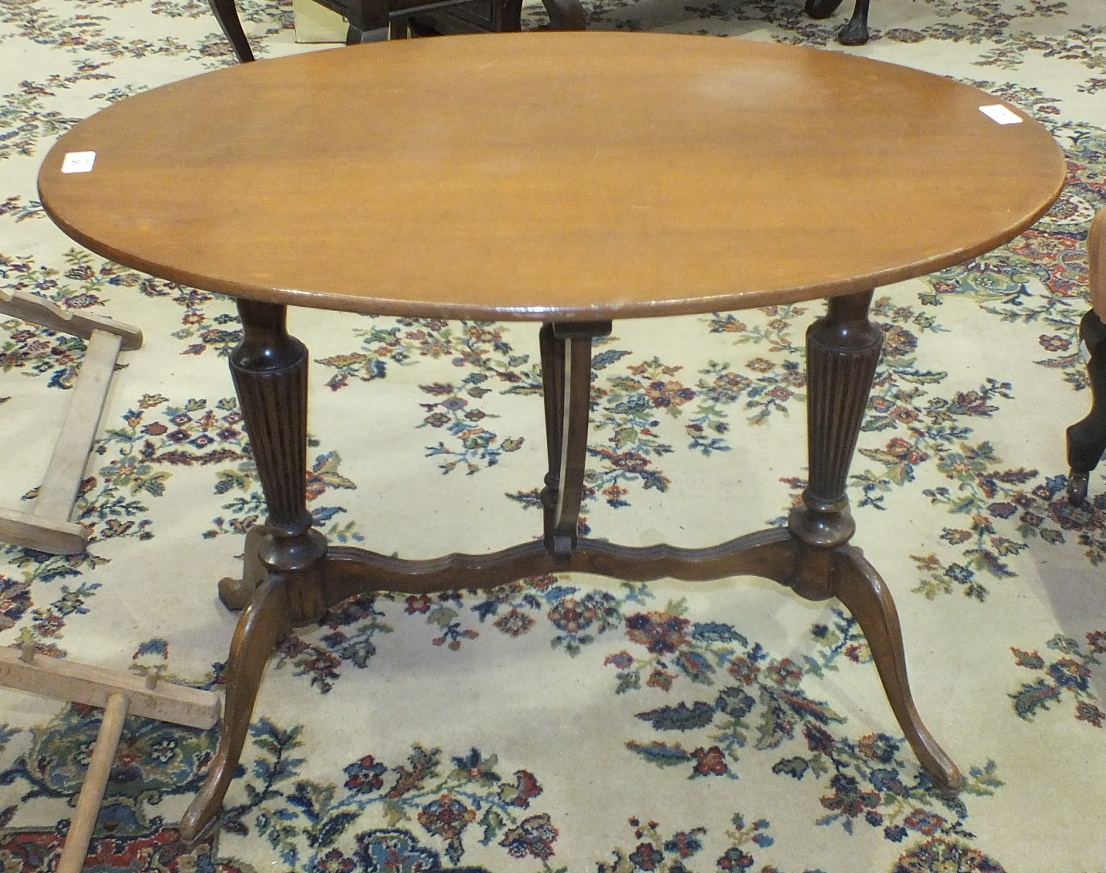 A reproduction stained wood oval occasional table on reeded folding legs, 80 x 56cm.