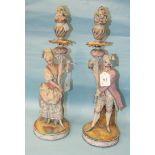 A pair of late-19th century Continental painted biscuit ceramic figural candlesticks, on circular