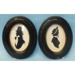 A pair of painted silhouettes of a gentleman and a lady in 18th century costume, signed 'Ray', in