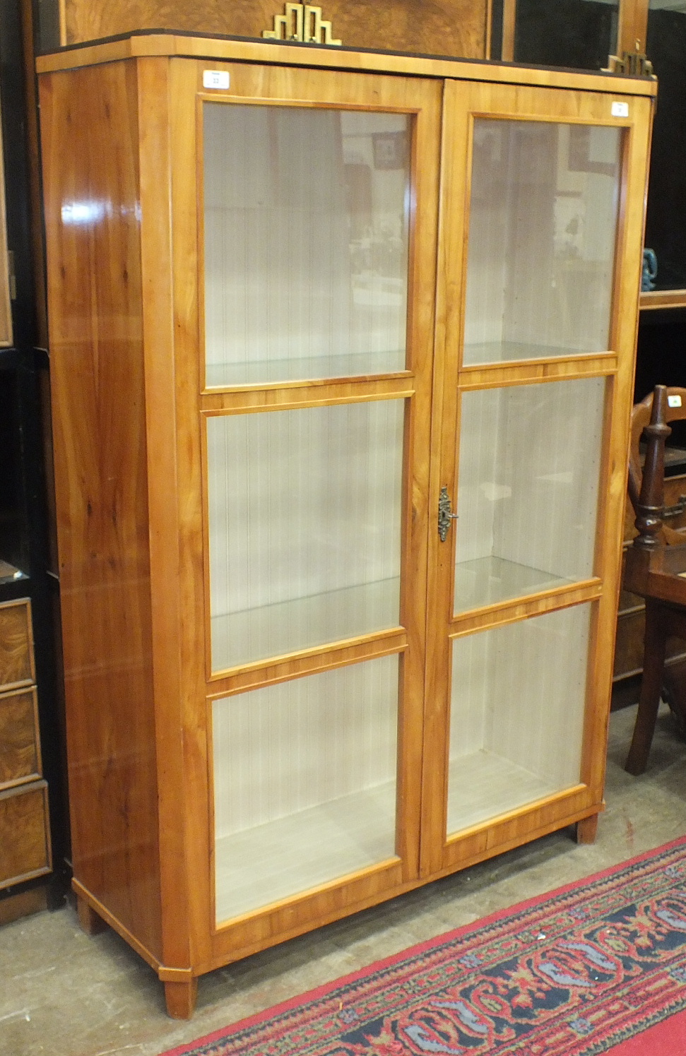 A Continental satinwood display cabinet, the rectangular top above a pair of glazed doors, 102cm