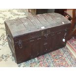 An early-20th century wood-bound metal-covered cabin trunk with domed hinged lid and leather