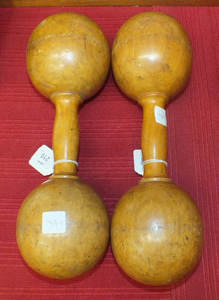 A pair of turned wood dumb bells, 32cm long.