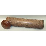 A carved wood document case of cylindrical form carved with a design of scrolls and flower heads