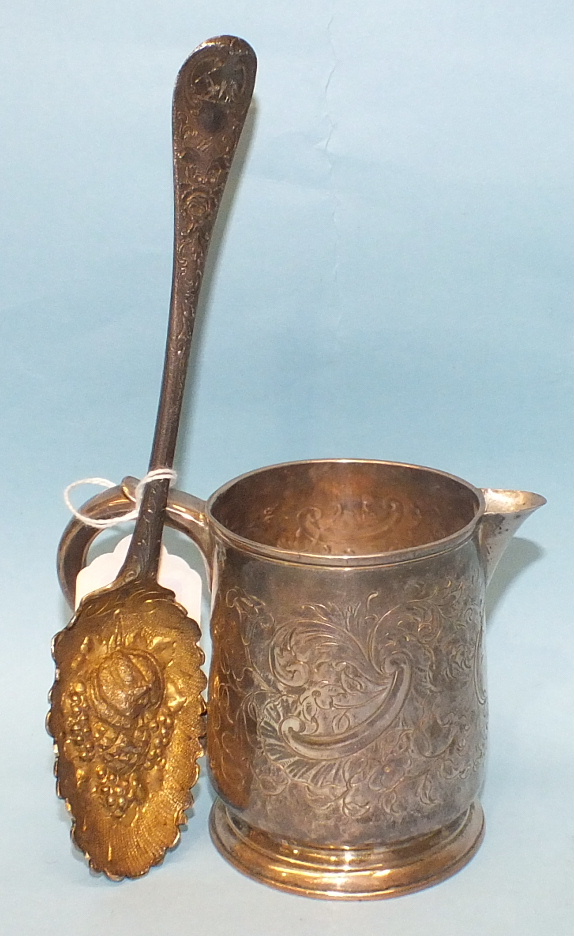 An engraved white metal jug, 9cm high and a white metal berry spoon, (2).