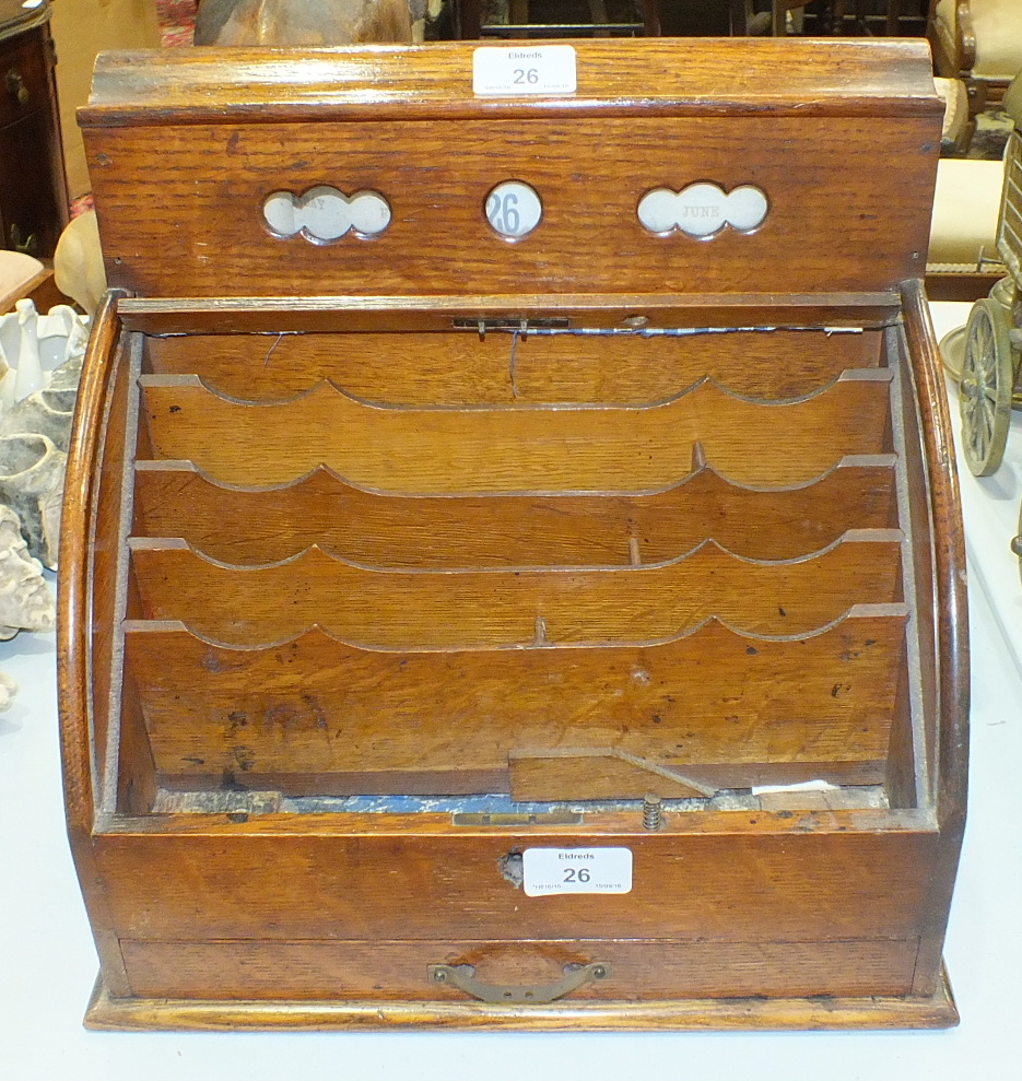 An Edwardian oak stationery box, the perpetual calendar above a tambour front, with fitted