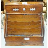 An Edwardian oak stationery box, the perpetual calendar above a tambour front, with fitted