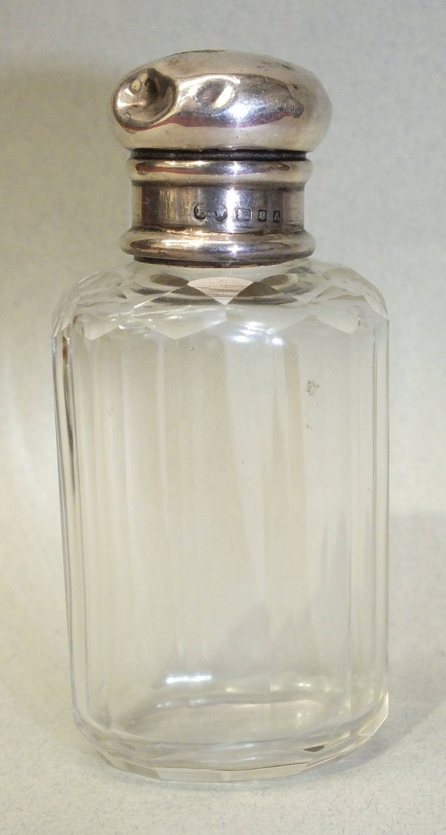 A small silver-topped scent bottle of oval cylindrical form, the lid hallmarked for London 1936, (