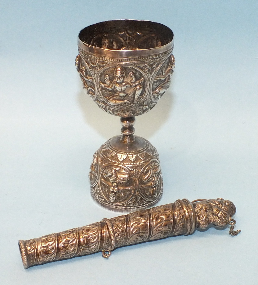 A Middle Eastern embossed white metal wager cup decorated with deities, 9cm high and a white metal