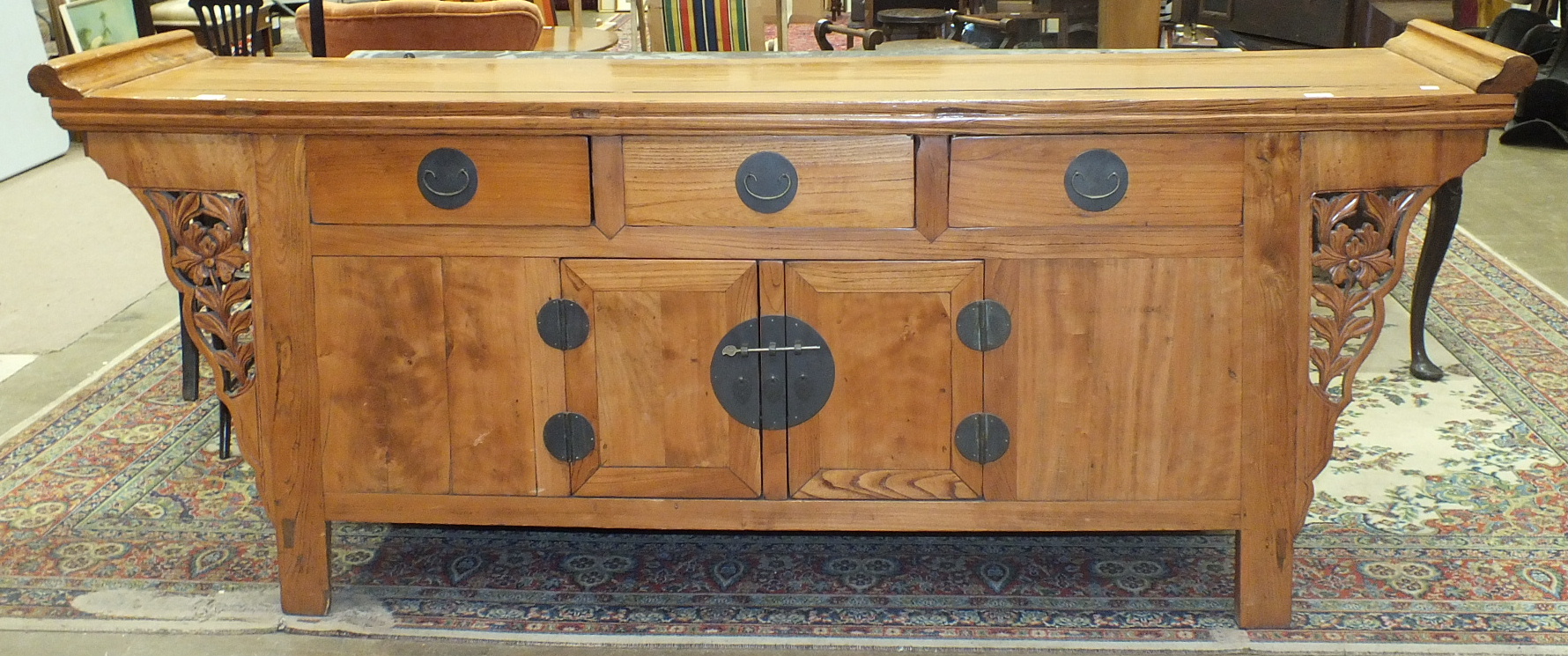 A Chinese-style stained wood sideboard, the rectangular top above three drawers and two cupboard