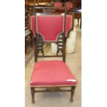 A stained wood upholstered salon chair with wings, having pierced and padded back and turned front