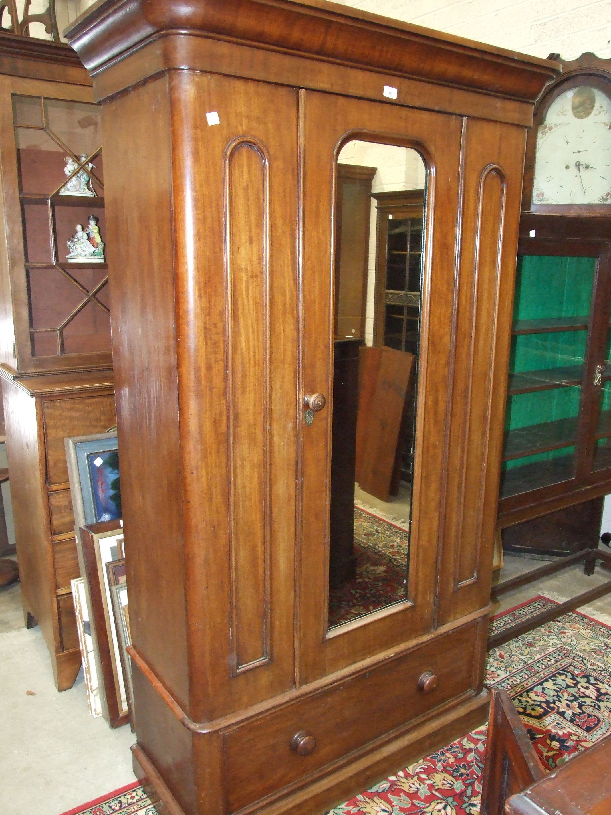A Victorian mahogany single-door wardrobe, the cornice above a mirror door, on base drawer, 120cm
