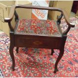 An Edwardian stained mahogany music stool with hinged seat, 61cm wide.