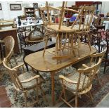 A modern stained wood and beech kitchen table and six stick-back beech chairs.