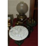 A set of weighing scales with ceramic plate and brass weights, a brass oil lamp, a pestle and mortar