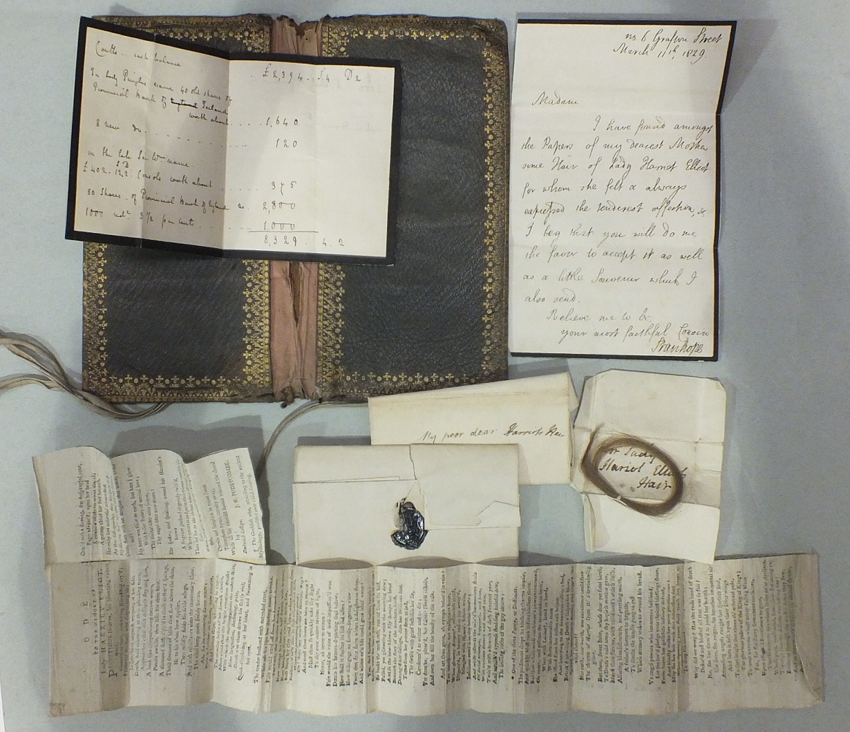 A leather wallet containing a letter dated 1829 and a lock of Lady Harriet Eliot's hair, a newspaper