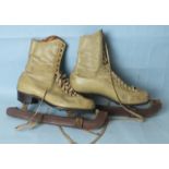A pair vintage cream leather ice skates with leather soles and blade covers.
