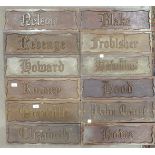 A collection of twelve rectangular carved hardwood name plates, including 'Hood', 'Revenge', '