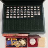 A part-set of forty-eight silver ingots depicting classic cars, approximately ___2.4oz, in case, two