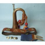 A copper and brass bugle with silk cord and tassels, a leather belt with eight cap badges and