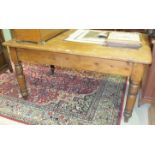 A stained pine kitchen table fitted with a single end drawer, on turned legs, 151 x 96cm.