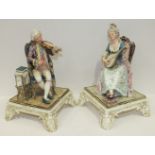 A pair of 19th century Royal Dux Bohemia porcelain figures of seated musicians playing a violin, (