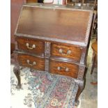 A mid-20th century mahogany bureau, the fall front above two drawers, on carved cabriole legs with