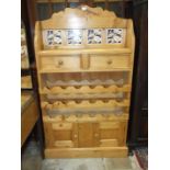 A stripped pine low dresser, the tiled back above a rectangular top, two small drawers, three wine