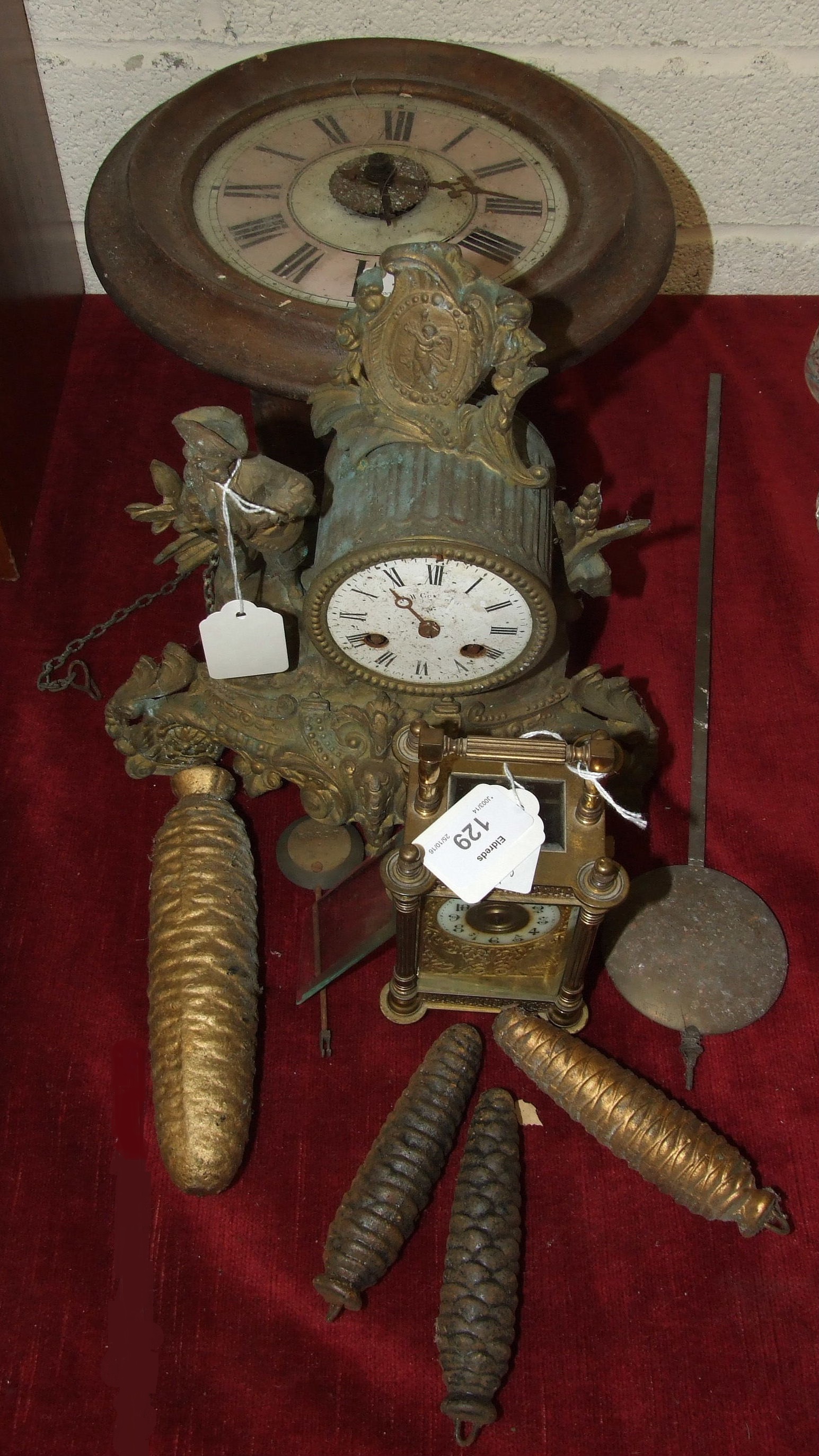 A circular wall hanging wood case 'Postman's' alarm clock, 27cm diameter, a gilt spelter mantel