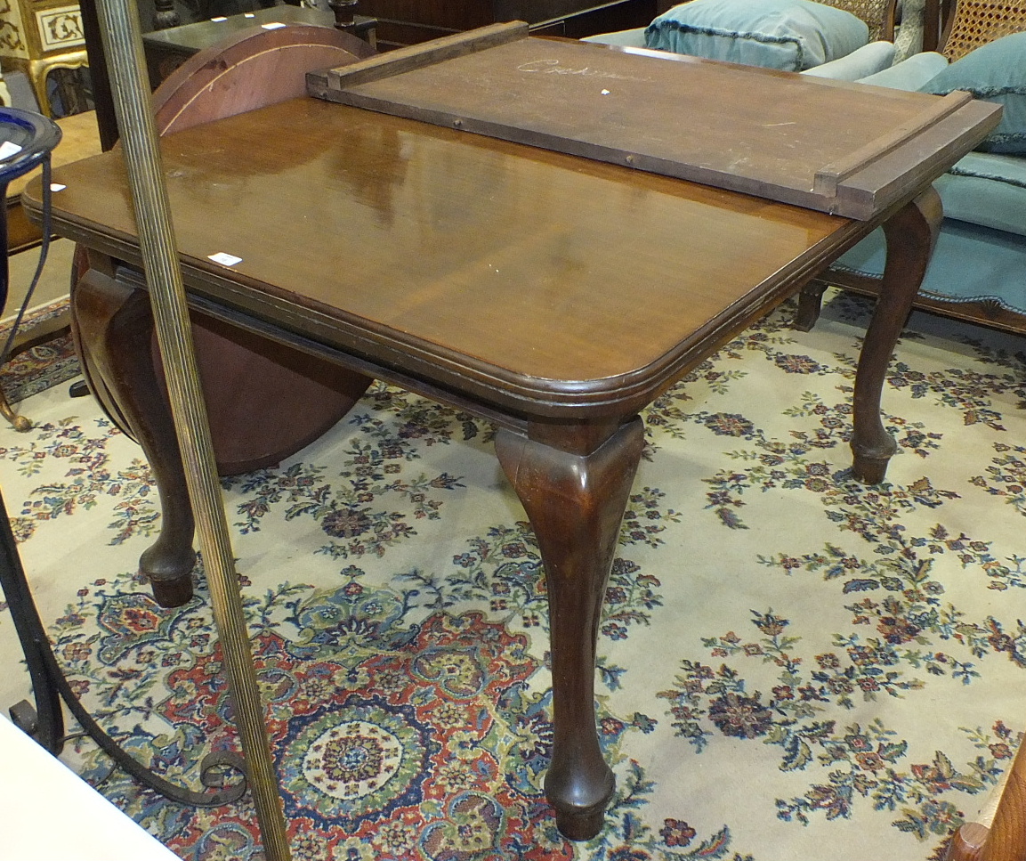 A 20th century mahogany extending dining table on cabriole legs, (with extra leaf) and a walnut