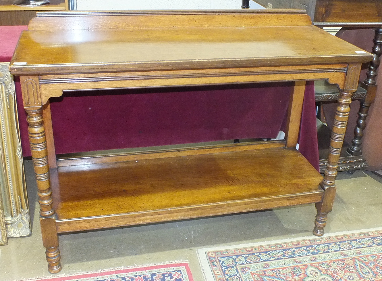 An Edwardian oak two-tier buffet on turned front columns, 130cm wide, 94cm high.