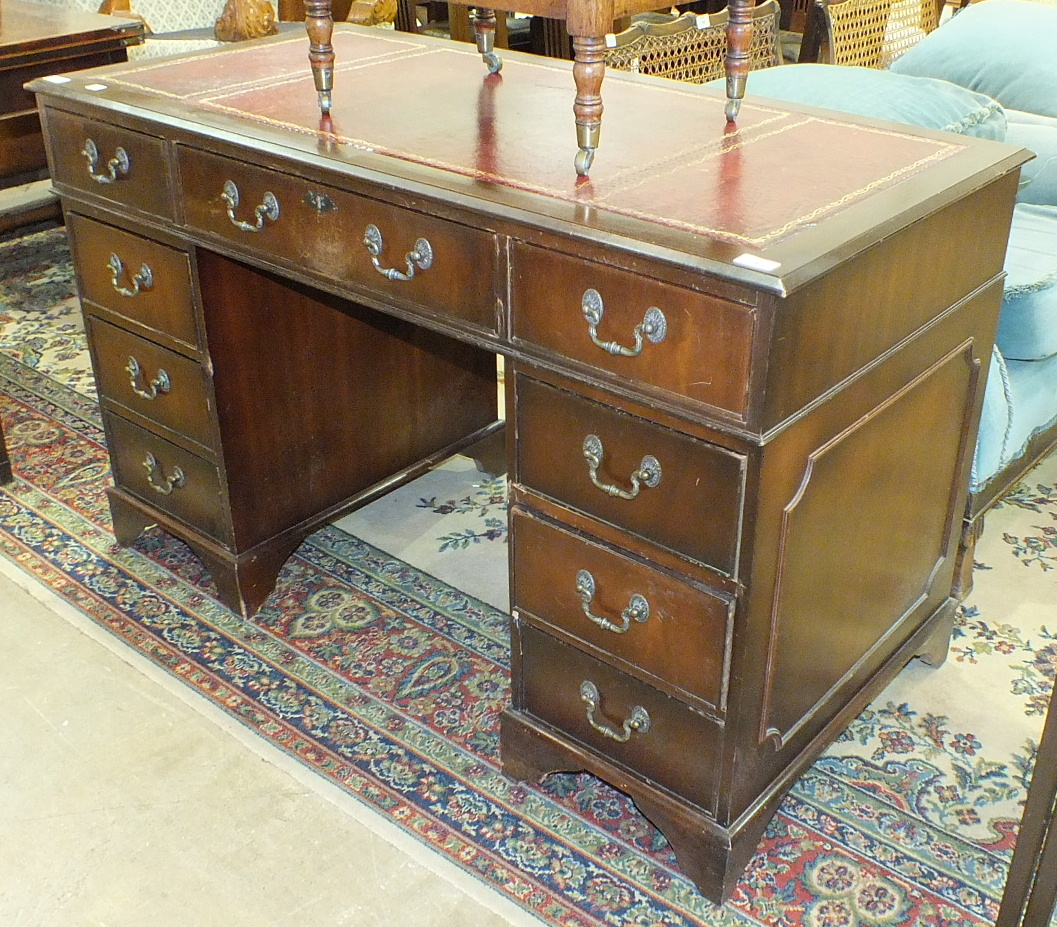 A modern mahogany-finished knee-hole desk, the rectangular top with inset writing surface and