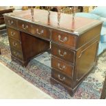 A modern mahogany-finished knee-hole desk, the rectangular top with inset writing surface and